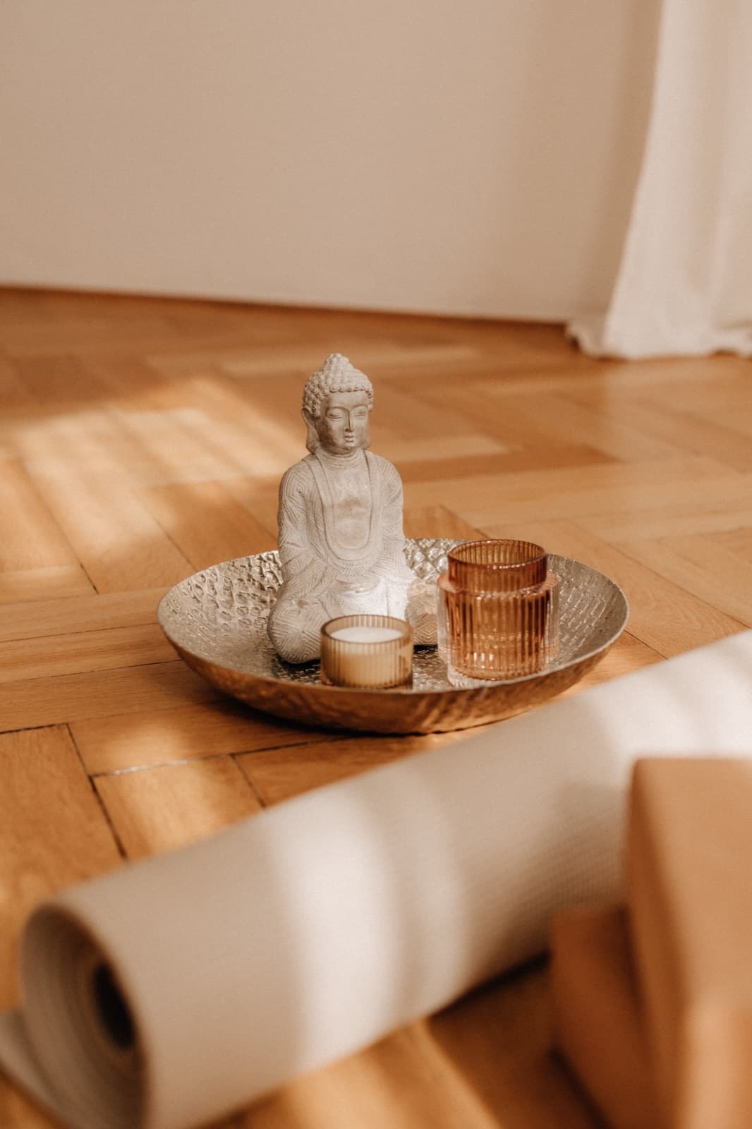 Buddha-Figur mit Kerze auf einem Tablett